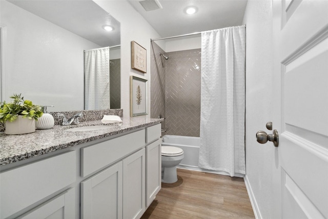 bathroom featuring visible vents, toilet, shower / bath combo, wood finished floors, and vanity