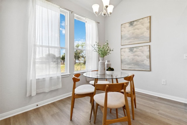 dining area with an inviting chandelier, wood finished floors, and baseboards