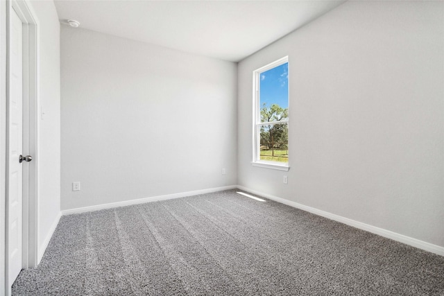 carpeted empty room with baseboards