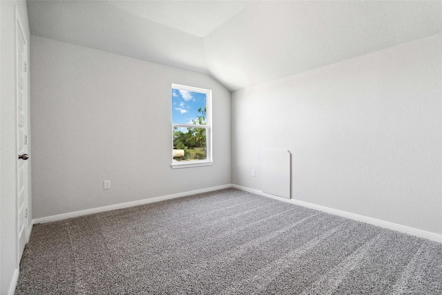 spare room with lofted ceiling, baseboards, and carpet floors