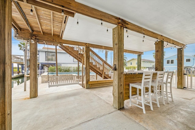 view of patio featuring an outdoor pool, a residential view, outdoor dry bar, and stairs