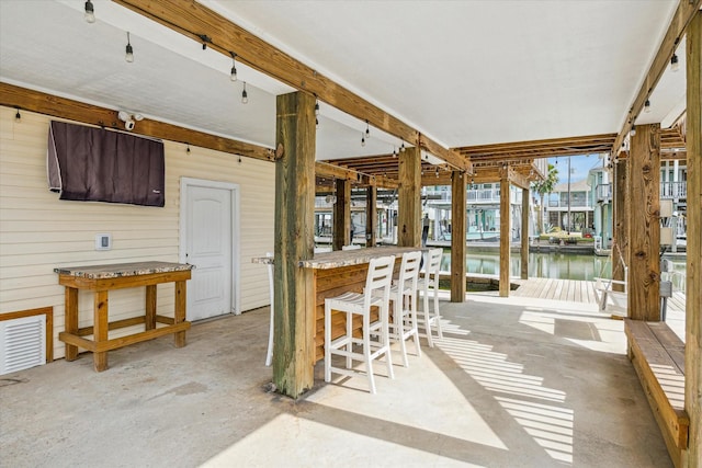 view of patio / terrace featuring visible vents, a water view, and outdoor dry bar