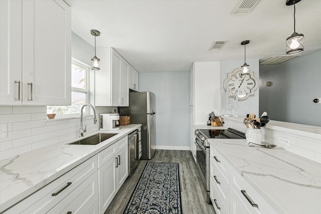 kitchen featuring a sink, stainless steel appliances, backsplash, and white cabinets