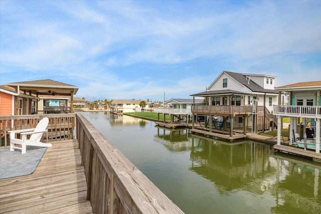 view of dock with a deck with water view and a residential view