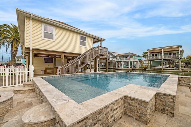 pool with stairs, a patio, a deck, and fence