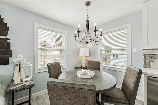16715 Montego Way, Jamaica Beach, TX 77554 - dining area with an inviting chandelier, wood finished floors, wine cooler, and plenty of natural light