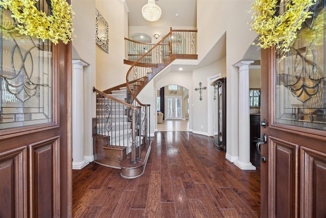 entrance foyer with baseboards, dark wood-style floors, stairs, and ornate columns