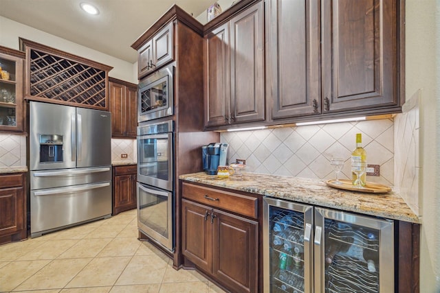 kitchen featuring backsplash, beverage cooler, light tile patterned floors, light stone counters, and stainless steel appliances