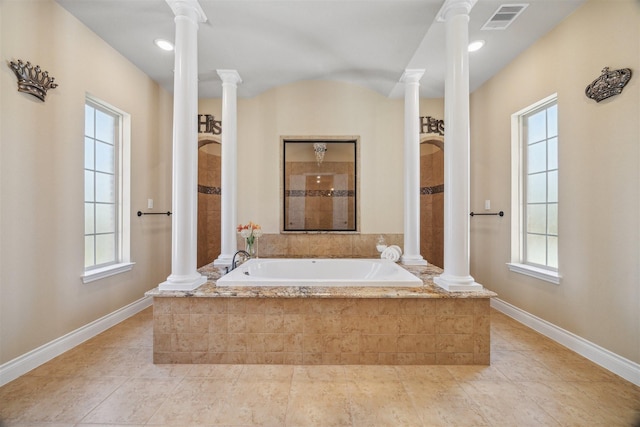 bathroom with a wealth of natural light, a bath, and ornate columns