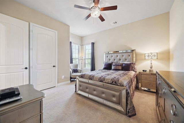 bedroom with a ceiling fan, baseboards, visible vents, and light carpet