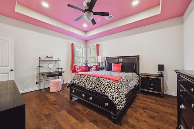 bedroom with visible vents, a tray ceiling, and wood finished floors