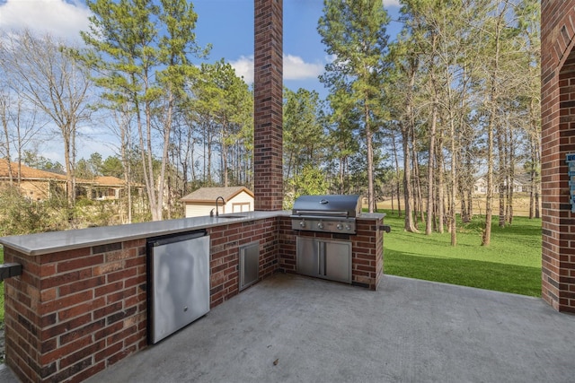 view of patio / terrace with area for grilling, an outdoor kitchen, and a sink