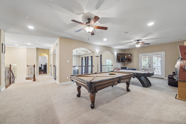 rec room featuring light colored carpet, visible vents, french doors, and arched walkways