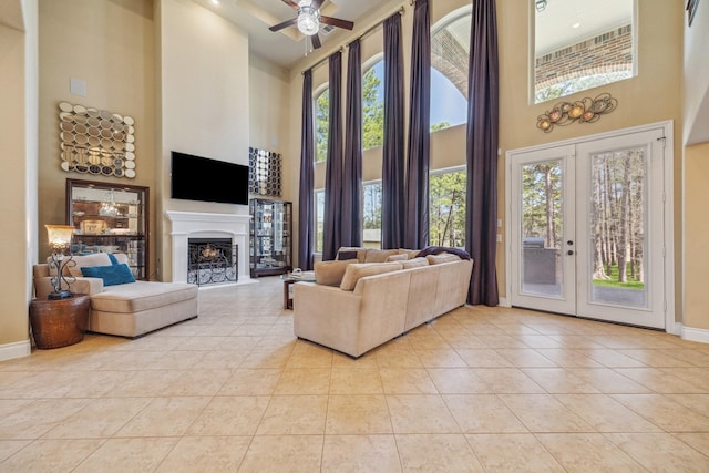 living room featuring light tile patterned floors, plenty of natural light, a fireplace, and baseboards