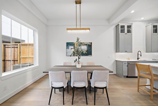 dining space featuring light wood-type flooring, plenty of natural light, and baseboards