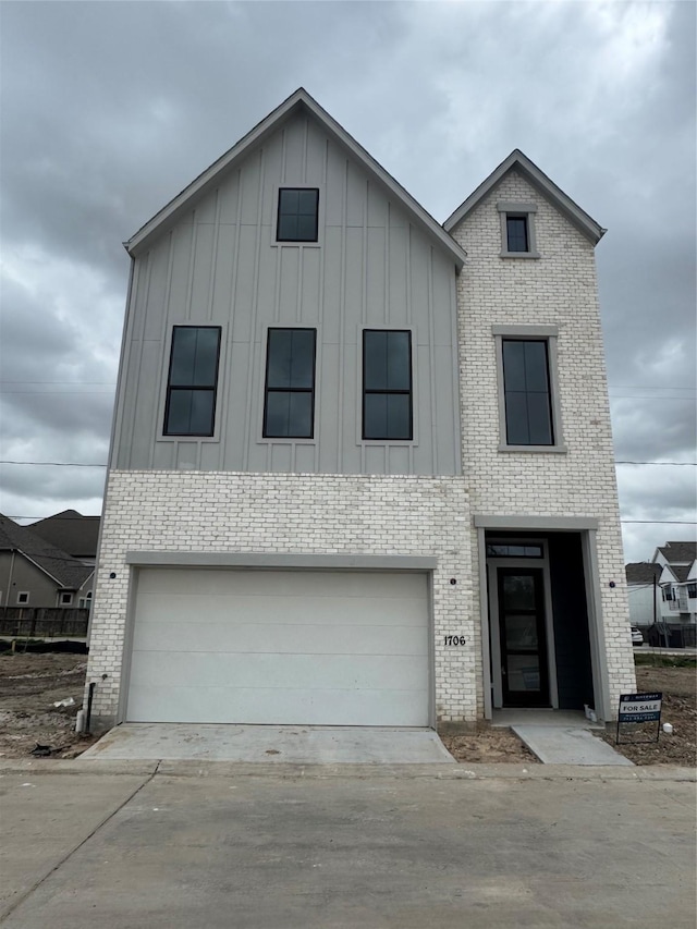 view of front of property with brick siding, board and batten siding, and driveway