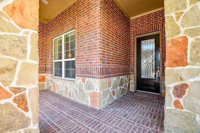 view of exterior entry featuring brick siding