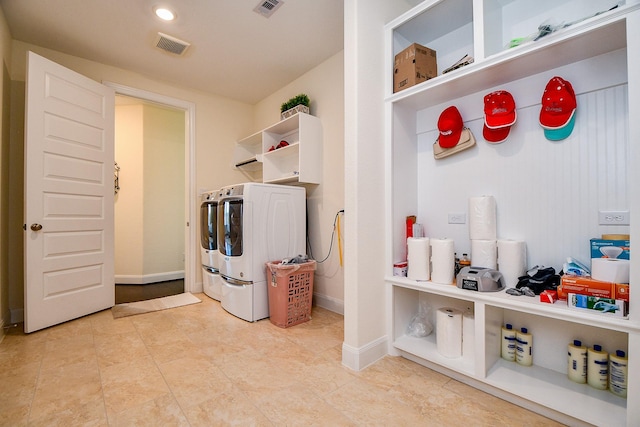 clothes washing area with laundry area, separate washer and dryer, visible vents, and baseboards