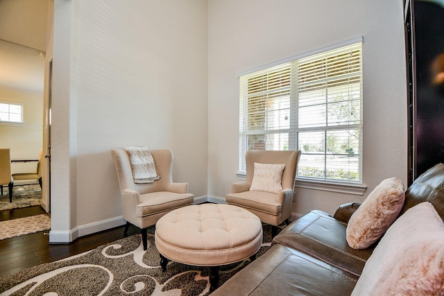 living area with a wealth of natural light, baseboards, and hardwood / wood-style flooring