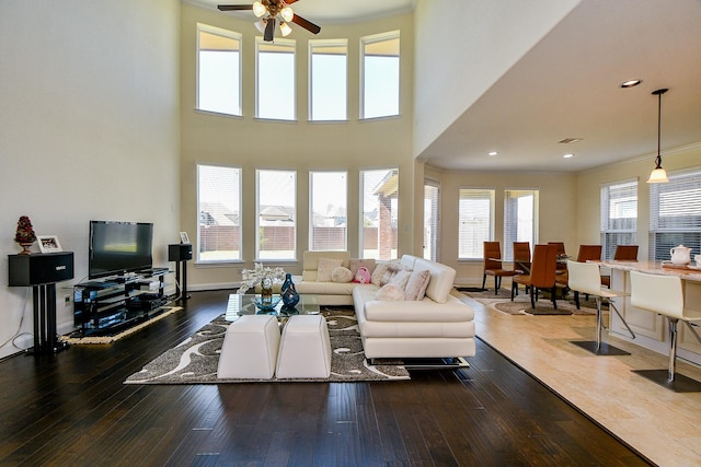 living room featuring recessed lighting, crown molding, baseboards, and wood-type flooring