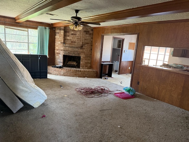 unfurnished living room featuring beam ceiling, carpet, wood walls, and a fireplace