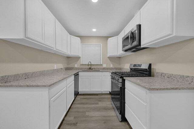806 Moody Ave, League City, TX 77573 - kitchen with a sink, appliances with stainless steel finishes, light wood-style flooring, and white cabinets
