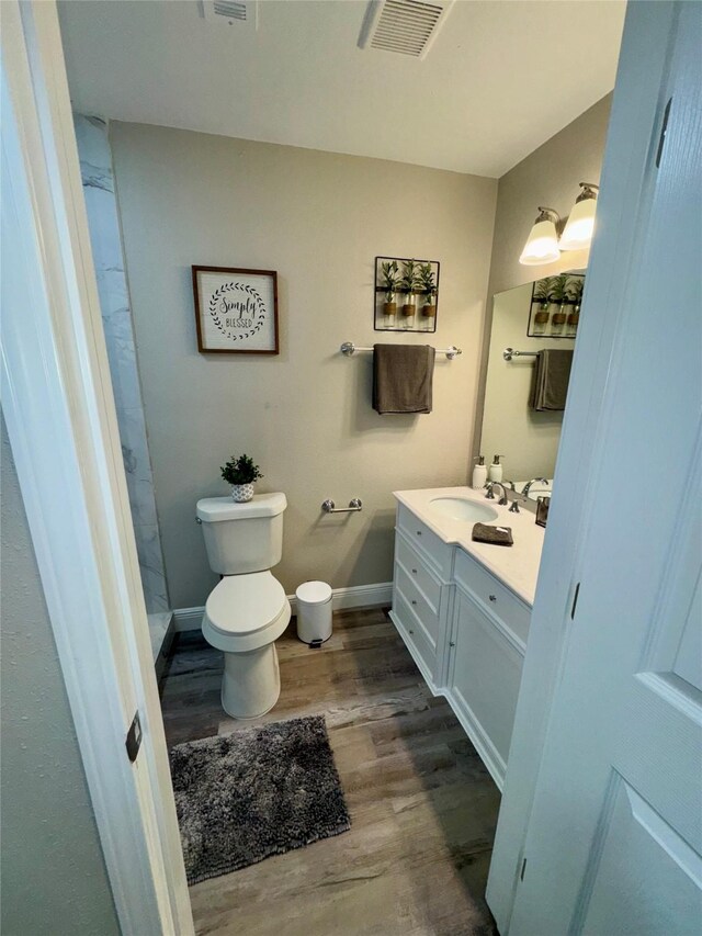 806 Moody Ave, League City, TX 77573 - bathroom with visible vents, toilet, wood finished floors, baseboards, and vanity