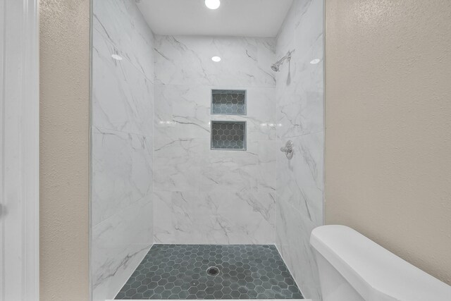 806 Moody Ave, League City, TX 77573 - full bathroom featuring a shower stall, toilet, and a textured wall