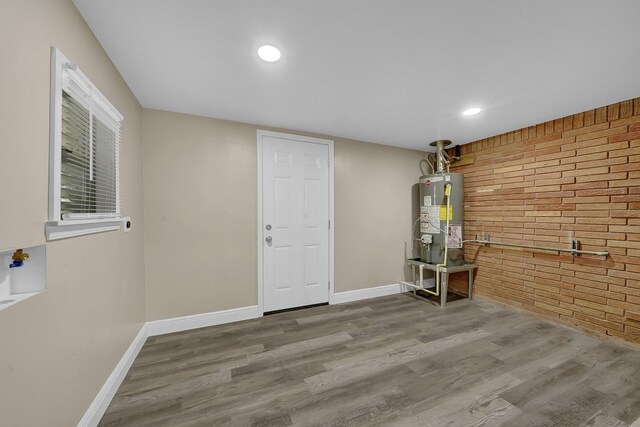 806 Moody Ave, League City, TX 77573 - interior space with baseboards, brick wall, wood finished floors, and water heater