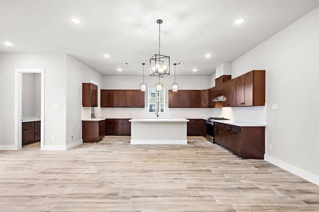 kitchen featuring gas range, recessed lighting, light wood-type flooring, and a kitchen island