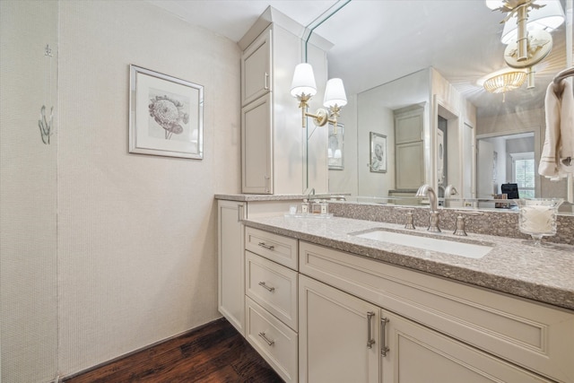 full bath with double vanity, wood finished floors, and a sink