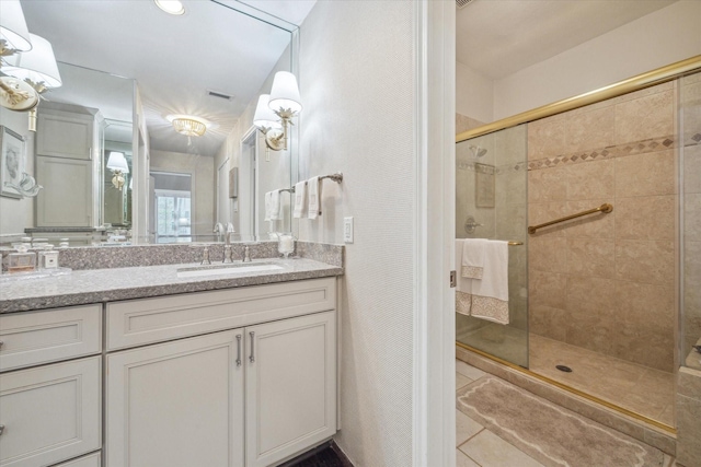 full bathroom featuring vanity, visible vents, and tiled shower