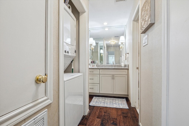 bathroom with vanity, recessed lighting, wood finished floors, and stacked washing maching and dryer