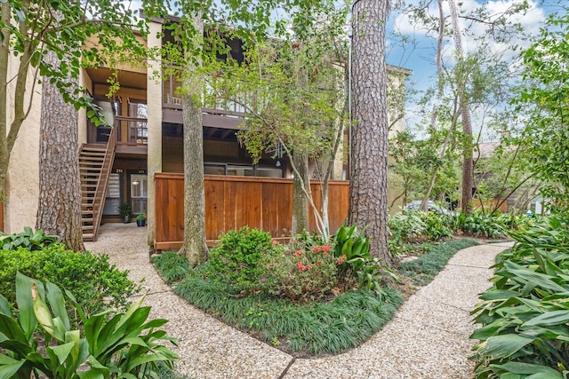 back of property featuring stairway and fence