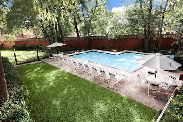 pool featuring a yard, a fenced backyard, and a patio area