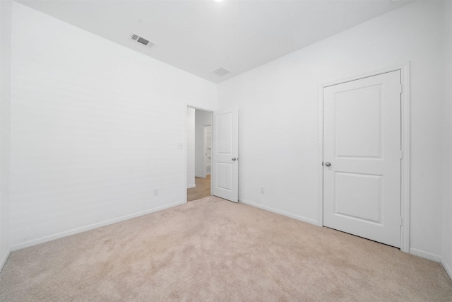 unfurnished bedroom featuring visible vents, light colored carpet, and baseboards