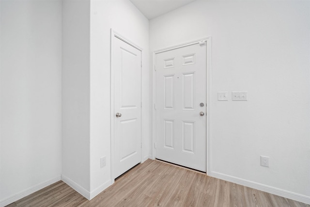 foyer with baseboards and light wood-type flooring