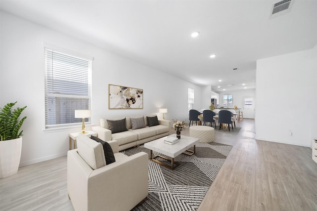 living area featuring light wood-type flooring, visible vents, baseboards, and recessed lighting