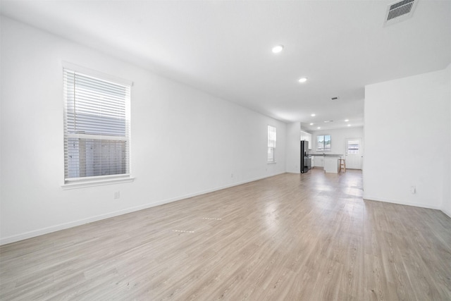 unfurnished living room featuring recessed lighting, baseboards, visible vents, and light wood-type flooring