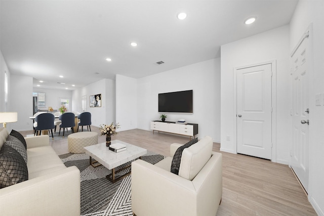 living area featuring recessed lighting, visible vents, baseboards, and light wood finished floors