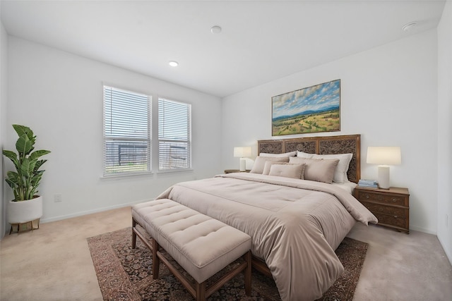 bedroom with light colored carpet and baseboards