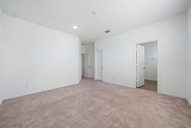 unfurnished bedroom with visible vents, light carpet, and baseboards