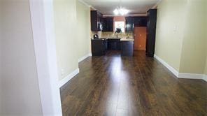 kitchen featuring pendant lighting, light countertops, dark wood-type flooring, and baseboards