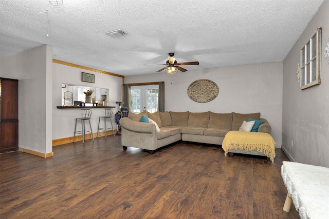 living area with wood finished floors, baseboards, visible vents, french doors, and a textured ceiling