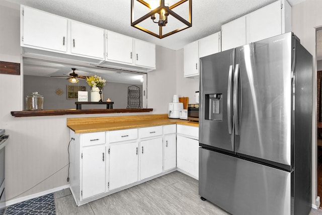 kitchen with stainless steel refrigerator with ice dispenser, a textured ceiling, white cabinets, light countertops, and ceiling fan