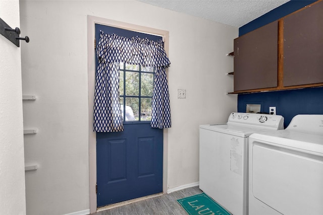 laundry room featuring baseboards, light wood-type flooring, cabinet space, a textured ceiling, and separate washer and dryer