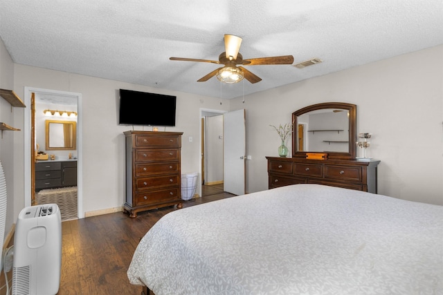 bedroom with visible vents, ensuite bathroom, a textured ceiling, a ceiling fan, and dark wood-style flooring