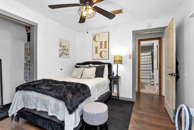 bedroom featuring wood finished floors, baseboards, visible vents, ceiling fan, and a textured ceiling