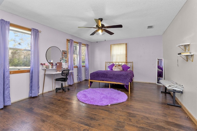 bedroom featuring wood finished floors, baseboards, and a textured ceiling