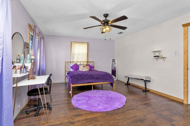 bedroom featuring ceiling fan, baseboards, a textured ceiling, and wood finished floors